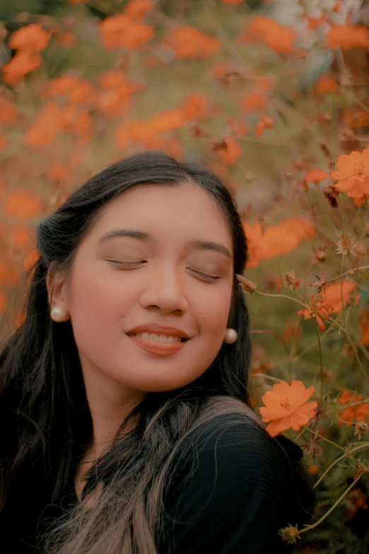 a woman standing in a field of orange flowers, an album cover, inspired by Ruth Jên, sumatraism, headshot profile picture, low quality photo, relaxing mood, still frame from a movie