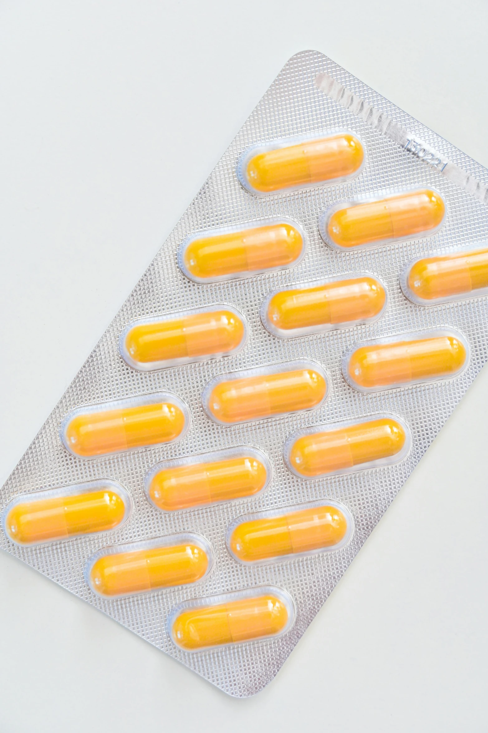 a pack of orange pills sitting on top of a white table, profile image