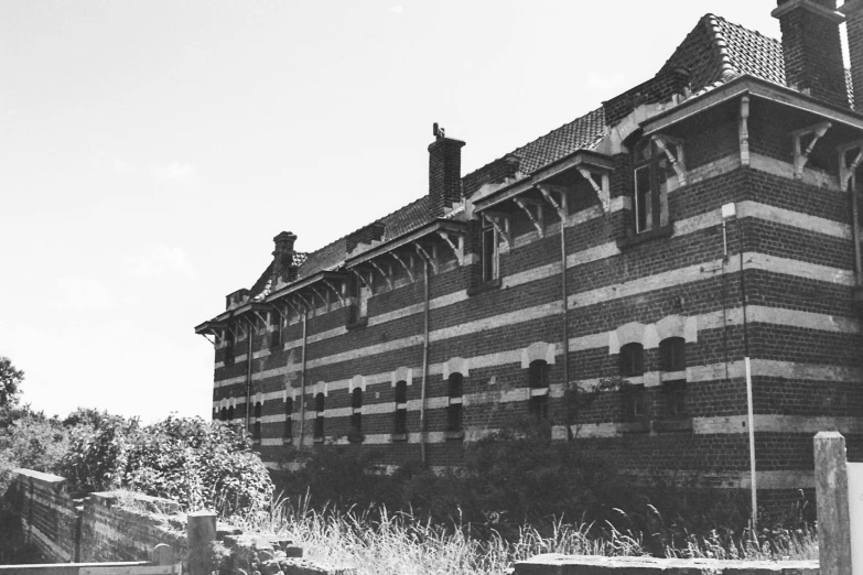 a black and white photo of an old building, unsplash, barbizon school, prison complex, striped, photographic print, military buildings