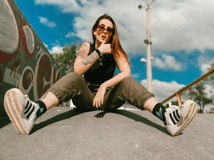 a woman sitting on the ground with her legs crossed, trending on pexels, graffiti, avatar image, wearing oakley sunglasses, tattooed, irish youtuber