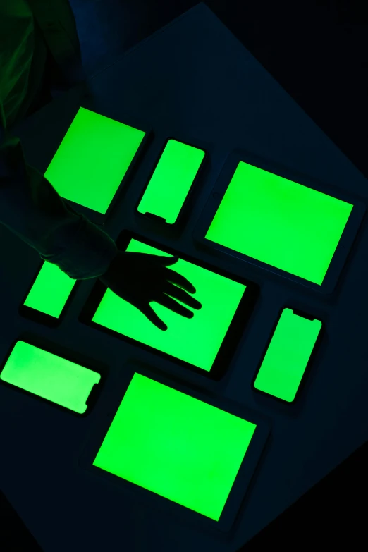 a person using a cell phone in the dark, a silk screen, interactive art, green radioactive glow, using a magical tablet, a green, displays