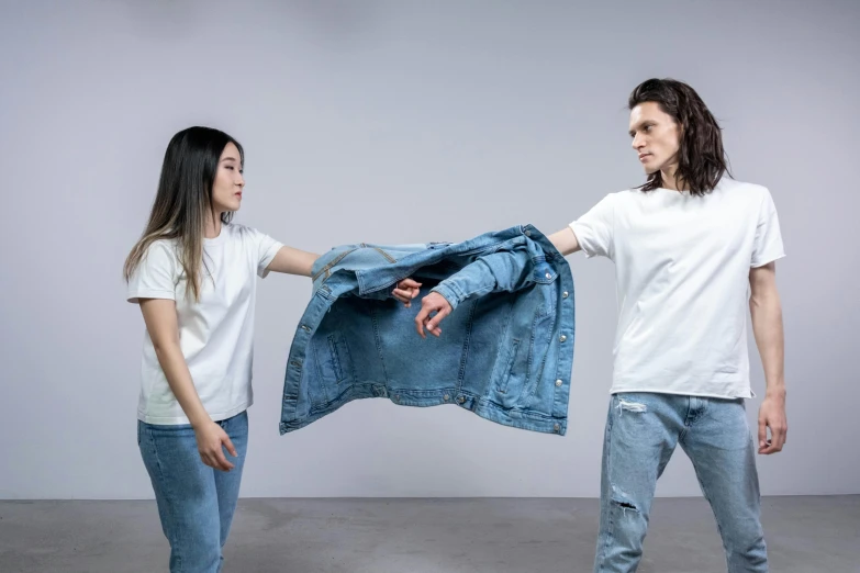 a man and a woman holding a denim jacket, inspired by Fei Danxu, trending on pexels, interactive art, dressed in a white t-shirt, dueling, minimal clothing, awkward