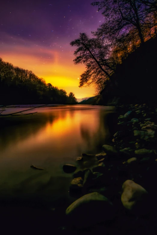 a large body of water next to a forest, by Sebastian Spreng, pexels contest winner, romanticism, colorful glow, cahaba river alabama, wales, skies behind