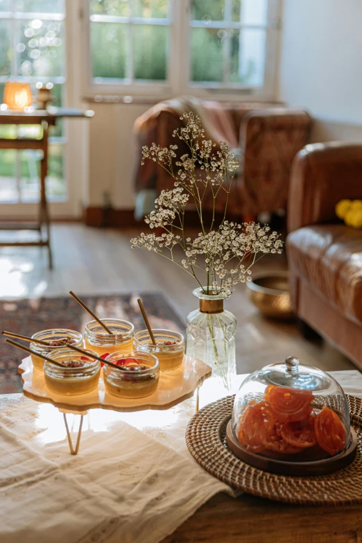 a table topped with jars of food on top of a wooden table, a picture, by Jan Tengnagel, trending on pexels, light and space, moroccan tea set, amber glasses, terrarium lounge area, fruit and flowers