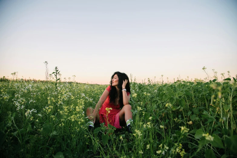 a woman sitting in a field talking on a cell phone, by Jessie Algie, pexels contest winner, happening, lush green, spring evening, justina blakeney, full body pose