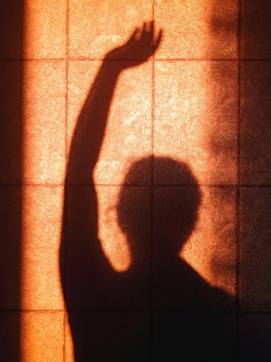 a shadow of a person on a tiled wall, by Jan Rustem, unsplash, arms raised, sunburn, 15081959 21121991 01012000 4k, backlit portrait