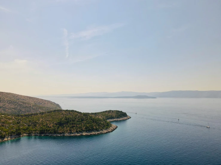 a small island in the middle of a large body of water, by Julian Allen, pexels contest winner, croatian coastline, dezeen, views to the ocean, ignant