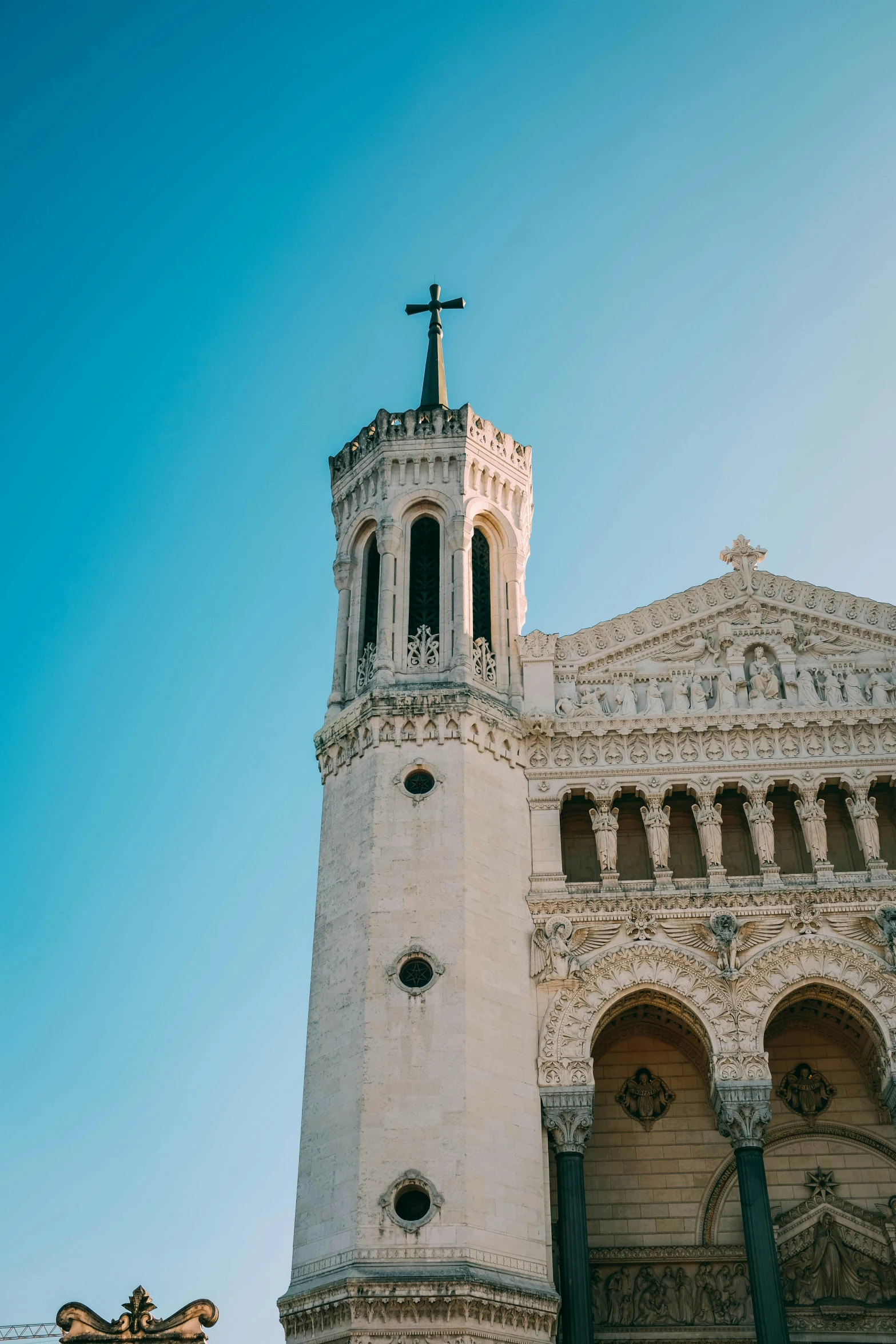 a large white building with a clock tower, by Raphaël Collin, trending on unsplash, romanesque, holy cross, monserrat gudiol, blue sky above, front profile