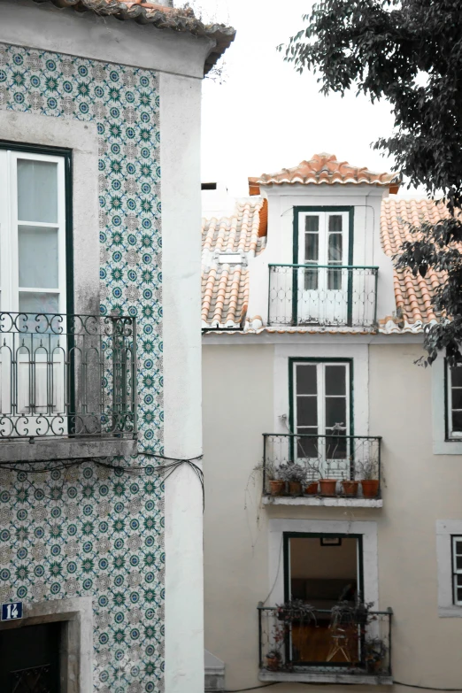 a couple of buildings that are next to each other, a mosaic, inspired by Nadir Afonso, arabesque, white houses, window view, tiled roofs, green alleys