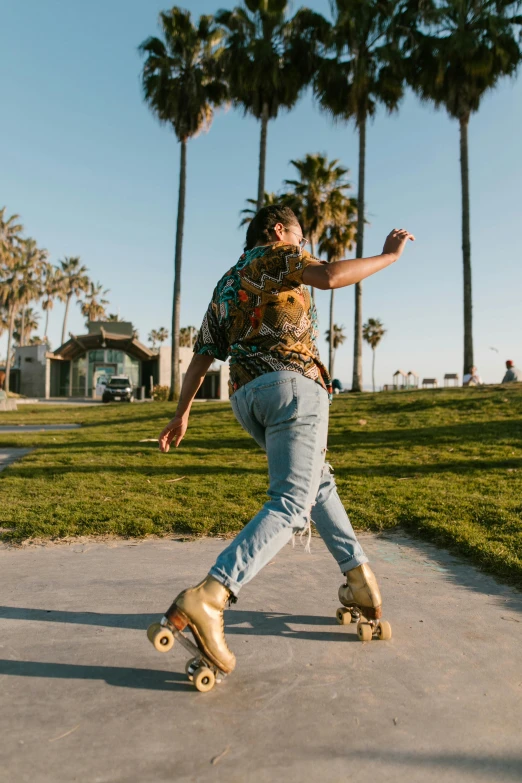 a man riding a skateboard down a sidewalk, unsplash contest winner, renaissance, with palm trees in the back, gold clothes, wearing a shirt and a jean, non binary model