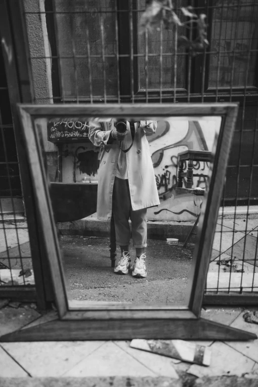 a person taking a picture of themselves in a mirror, a black and white photo, inspired by Vivian Maier, tumblr, realism, hip hop aesthetic, dressed in an old white coat, grunge aesthetic!!! (, frontshot