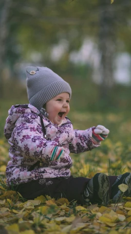 a little girl that is sitting in the grass, by Sven Erixson, pexels contest winner, action shot girl in parka, knitted hat, excited, 15081959 21121991 01012000 4k