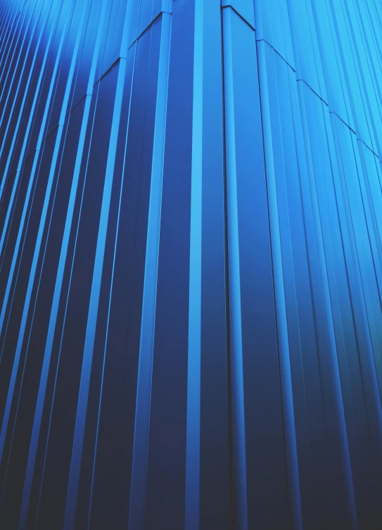 a tall building with a blue sky in the background, glowing tiny blue lines, metal surfaces, profile image, striped