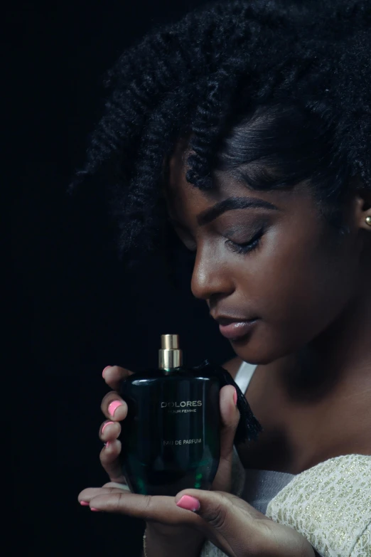 a woman holding a bottle of perfume in her hands, an album cover, inspired by Theo Constanté, pexels contest winner, black main color, dark green, curls, skincare