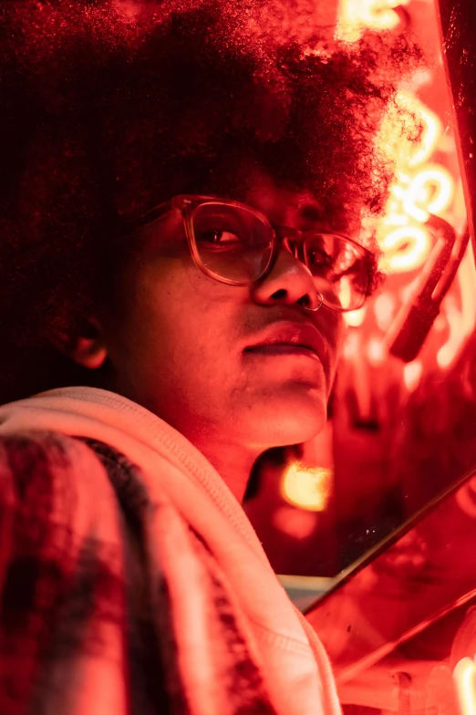 a close up of a person holding a pair of scissors, afrofuturism, red light from some windows, fire lit, wearing red tainted glasses, student