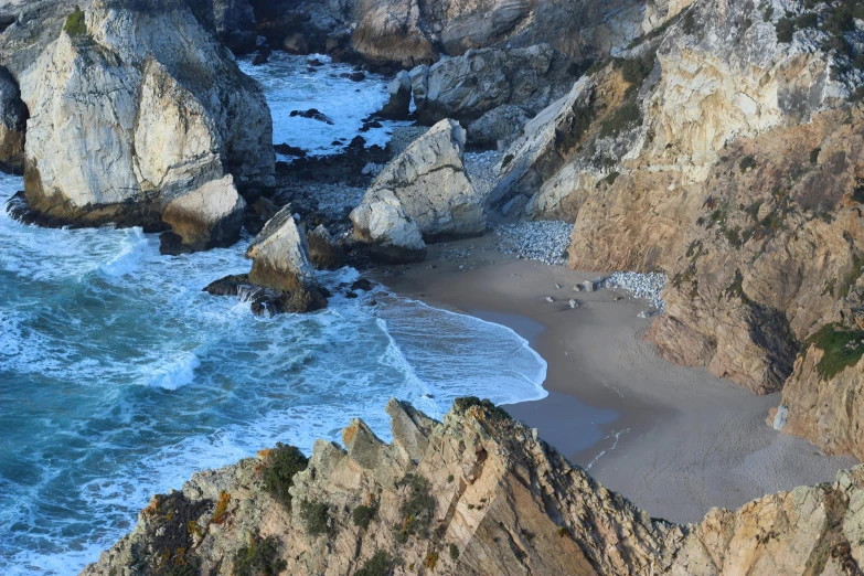 a group of people standing on top of a cliff next to the ocean, by David Simpson, pexels contest winner, california coast, rock and sand around, 2 5 6 x 2 5 6 pixels, beach is between the two valleys