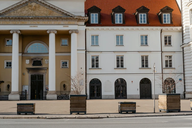 a couple of benches sitting in front of a building, by Emma Andijewska, pexels contest winner, berlin secession, czeslaw znamierowski, square, in the center of the image, hammershøi