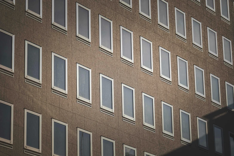 a very tall building with lots of windows, inspired by David Chipperfield, unsplash, brown, window, retro stylised, square shapes