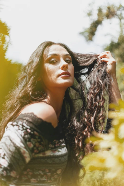 a woman with long hair standing in a field, long swirly dark hair, giorgia meloni, with ivy, promo image