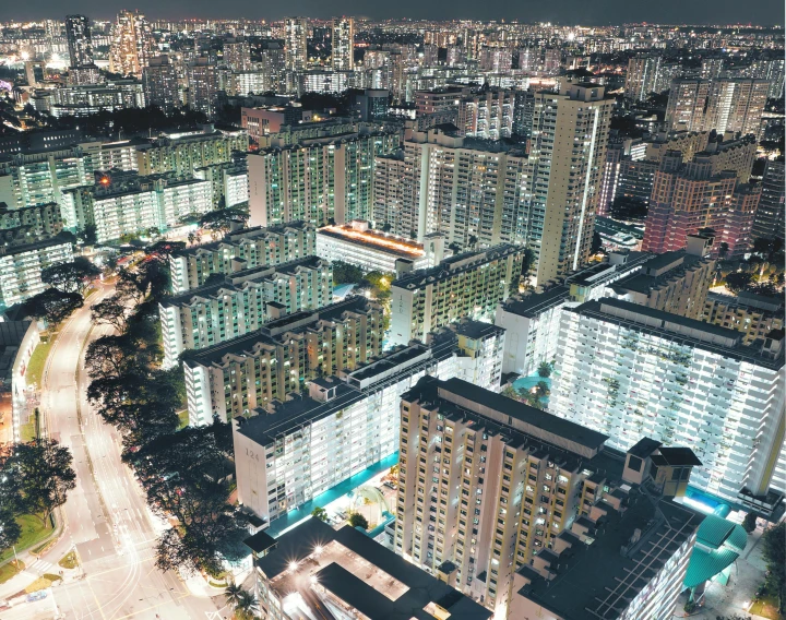 an aerial view of a city at night, by Benjamin Block, pexels contest winner, concrete housing, set on singaporean aesthetic, brutalism buildings, ultra wide angle isometric view