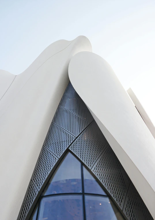 a close up of a building with a sky background, inspired by Zaha Hadid, unsplash, art nouveau, white concrete, futuristic marrakech, back shark fin, fzd school of design