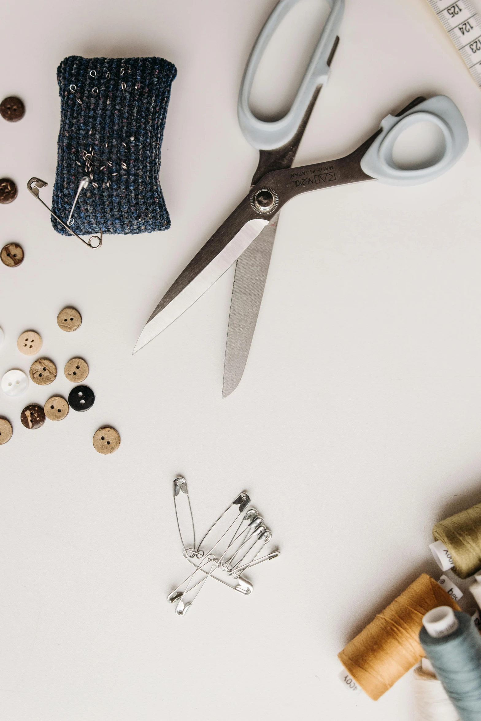 a pair of scissors sitting on top of a table, a cross stitch, trending on pexels, metallic buttons, thumbnail, inspect in inventory image, disassembled