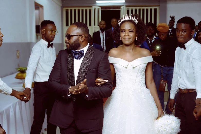 a man in a tuxedo and a woman in a wedding dress, by Chinwe Chukwuogo-Roy, pexels, happening, instagram post, brown, commander, leading to a beautiful