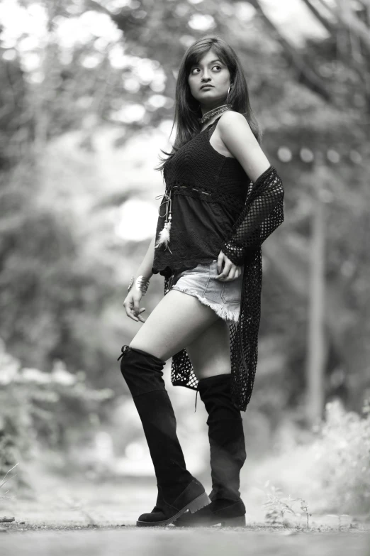 a woman standing in the middle of a dirt road, kneehigh boots, indian super model, monochrome:-2, an emo girl