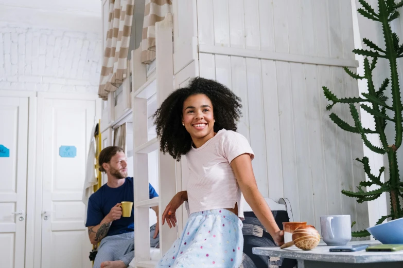 a woman standing in a kitchen next to a man, pexels contest winner, happening, happy girl, wearing a baggy pajamas, with afro, wearing a tanktop and skirt