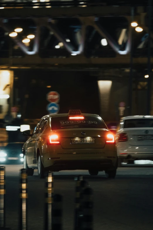 a group of cars driving down a street at night, taxis, anamorphic cinematography, square, ad image