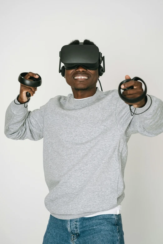 a man holding two video game controllers in his hands, afrofuturism, floating vr headsets, holding it out to the camera, 2019 trending photo, portrait photo