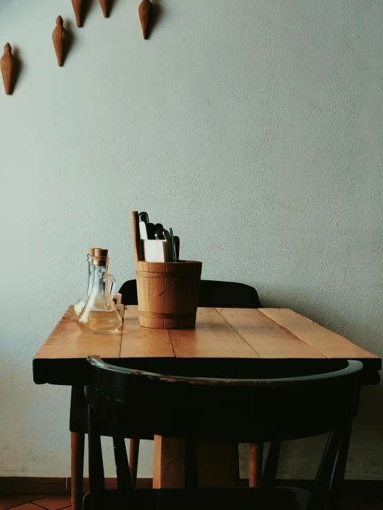 a wooden table and chairs in a room, trending on unsplash, is ((drinking a cup of tea)), profile image, lo fi, chef table