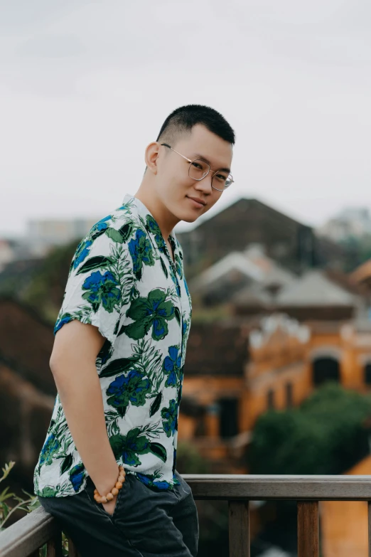 a man standing on top of a balcony next to a building, inspired by Patrick Ching, happening, wearing a shirt, phong shaded, profile image, floral