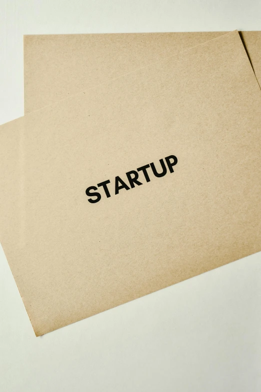 a stack of brown paper with the word start up written on it, an album cover, unsplash, private press, biotech, x logo, starship, customers