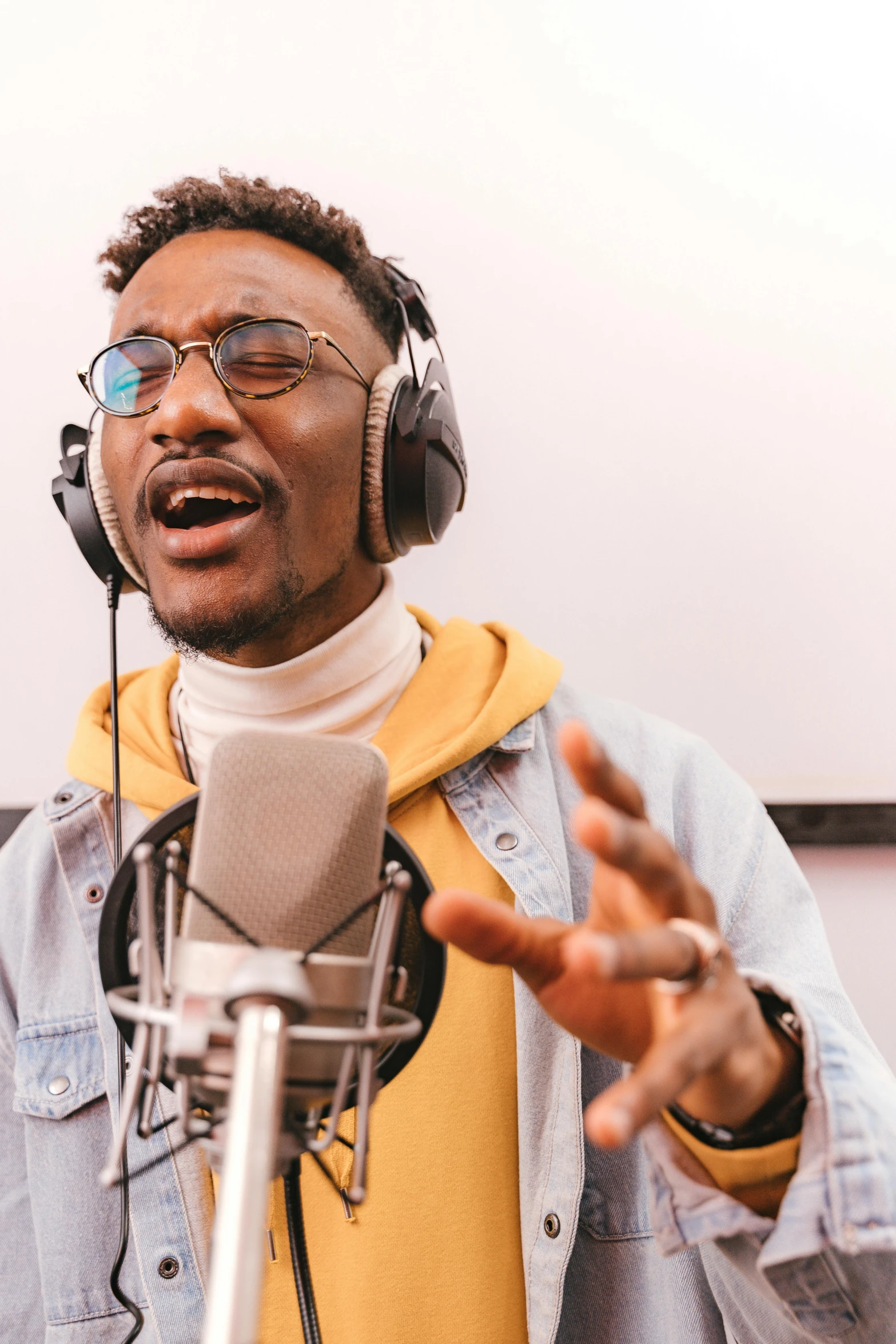 a man wearing headphones standing in front of a microphone, trending on pexels, happening, ashteroth, wholesome, kano), premium quality