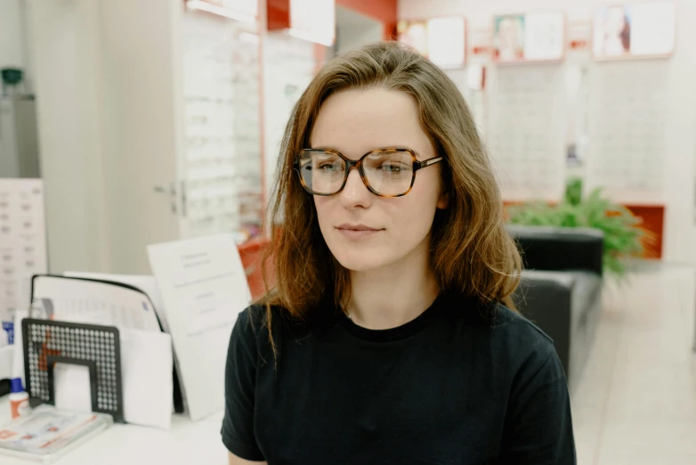 a woman sitting at a table with a plate of food in front of her, a picture, by Attila Meszlenyi, featured on reddit, wearing black frame glasses, lachlan bailey, medium close up portrait, premium quality