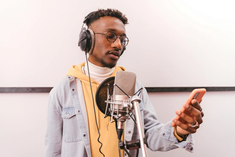 a man wearing headphones standing in front of a microphone, trending on pexels, ashteroth, studio quality product, background image, instagram picture