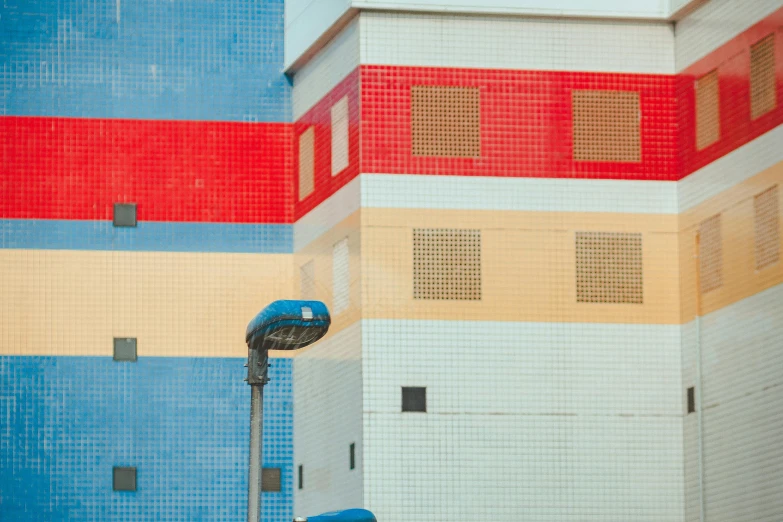 a man riding a skateboard down a street next to a tall building, pixel art, inspired by Bauhaus, unsplash, modular constructivism, blue and red color palette, location ( favela _ wall ), clemens ascher, square lines