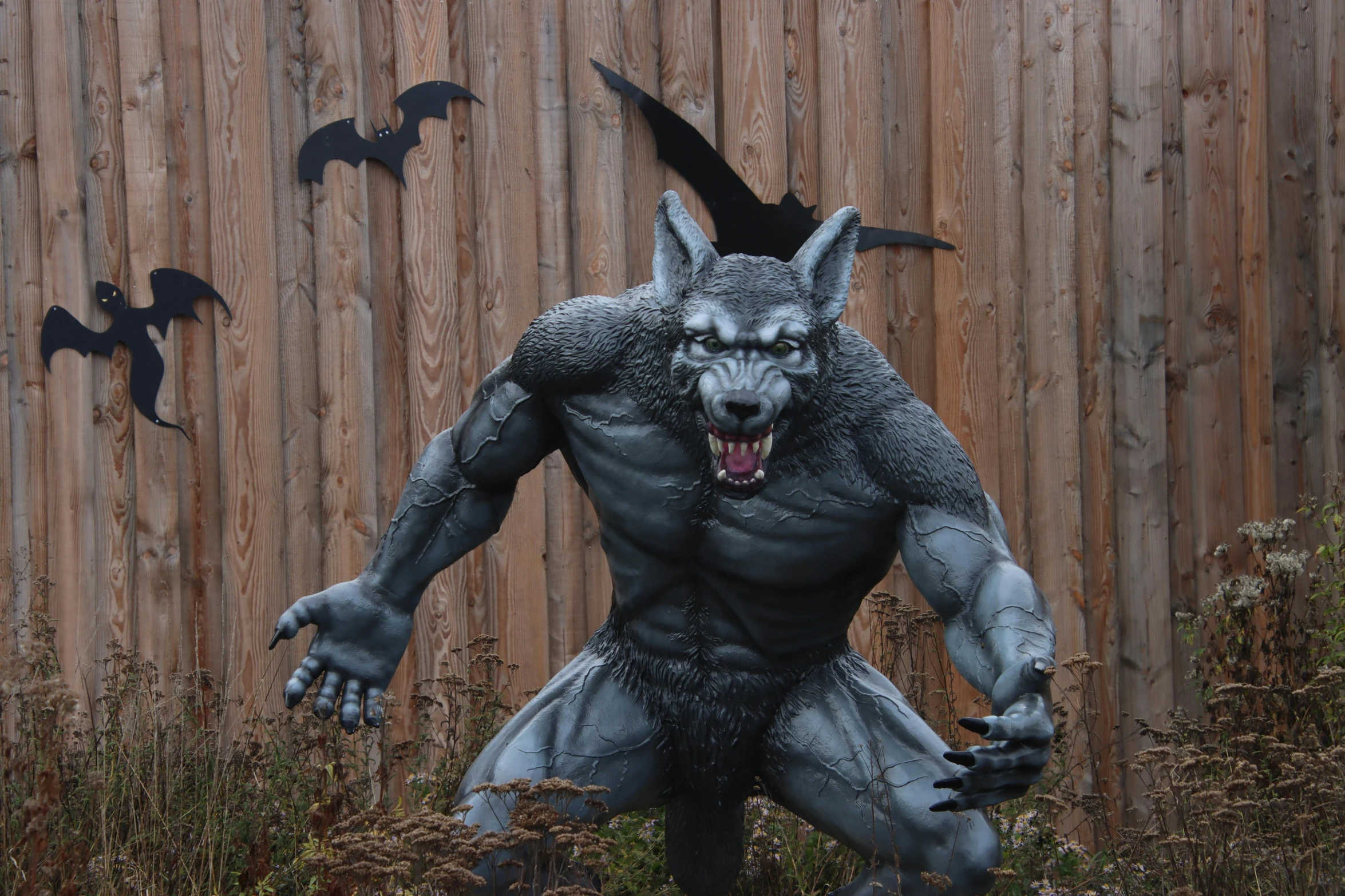 a statue of a demon standing in front of a fence, dark grey wolf, batman, 7 feet tall, item
