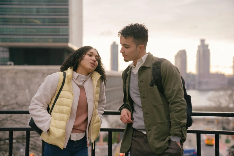 a man and a woman standing next to each other, trending on pexels, happening, rooftop romantic, calmly conversing 8k, teenage girl, bite her lip