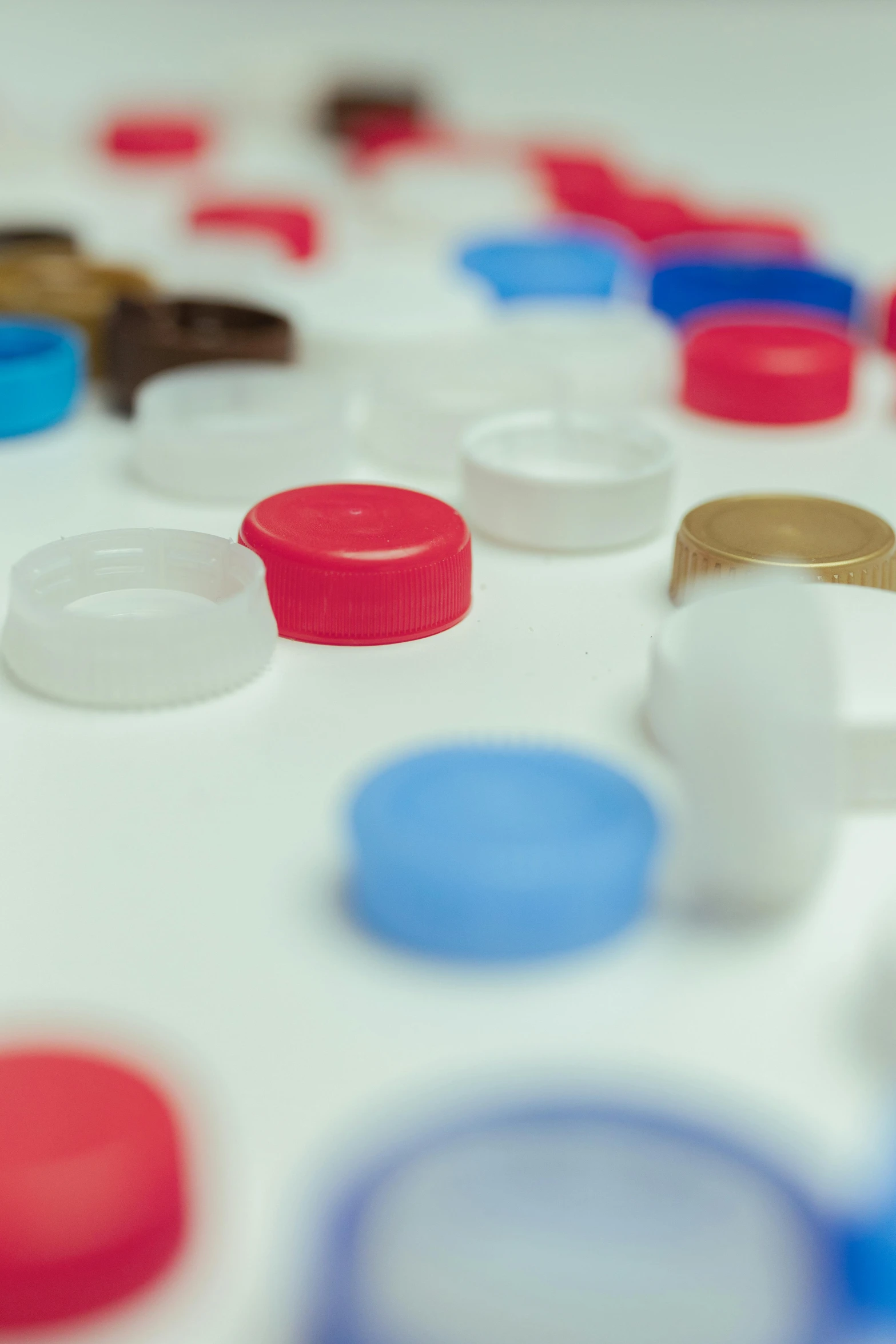 a table topped with lots of different colored cups, a picture, by Doug Ohlson, plasticien, mechanical implants, thumbnail, caps sideways, close-up product photo