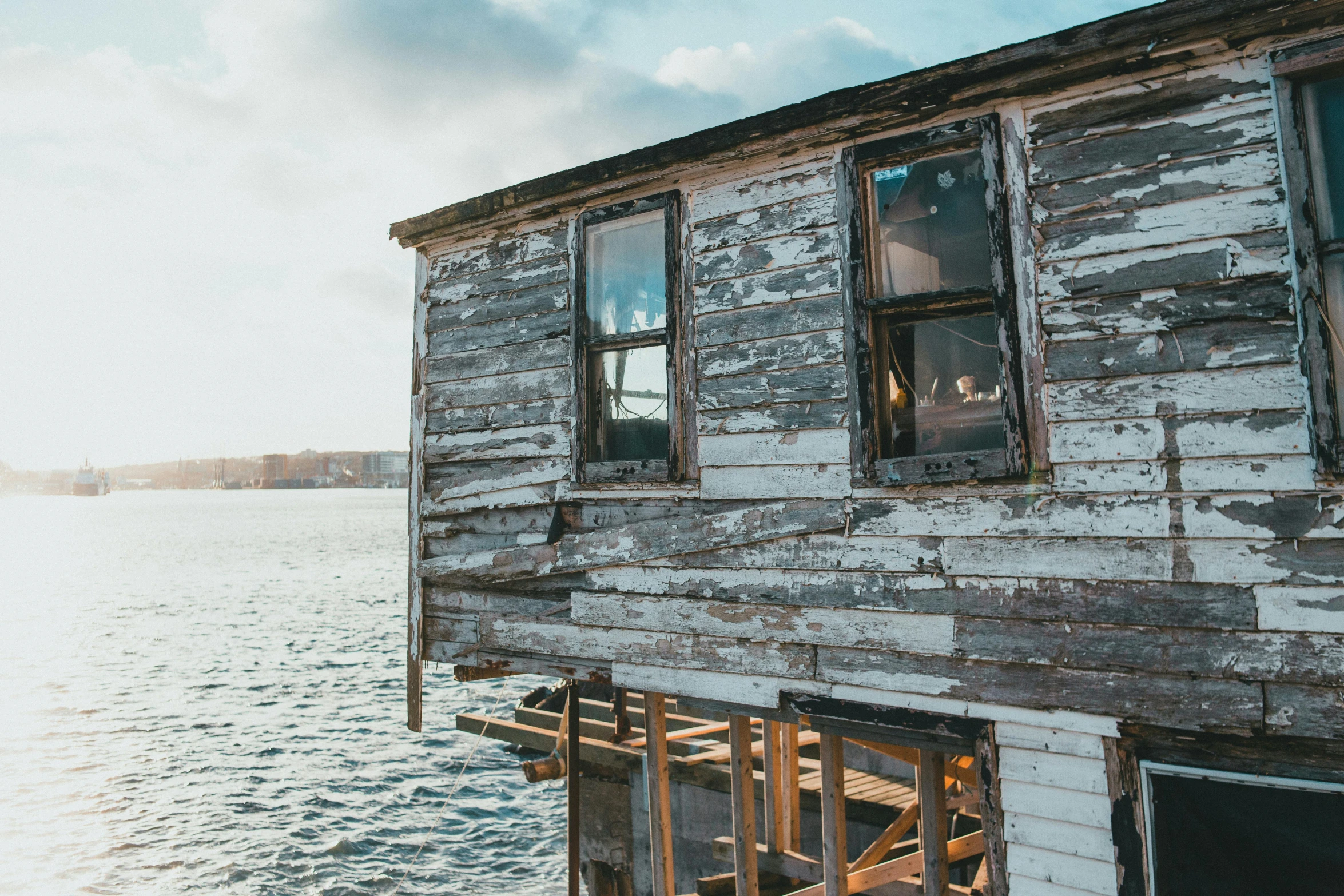 a wooden building sitting on top of a body of water, by Carey Morris, pexels contest winner, photo of poor condition, sunny bay window, slide show, restoration