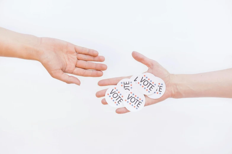 a person handing a sticker to another person's hand, by Arabella Rankin, pexels contest winner, interactive art, set against a white background, election poster, round-cropped, cards