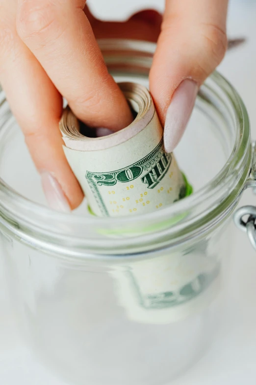 a person putting money in a glass jar, kailee mandel, null, thumbnail, small