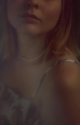 a close up of a woman with a flower in her hair, an album cover, inspired by Elsa Bleda, photorealism, pearl choker, wearing a camisole, intoxicatingly blurry, sydney sweeney