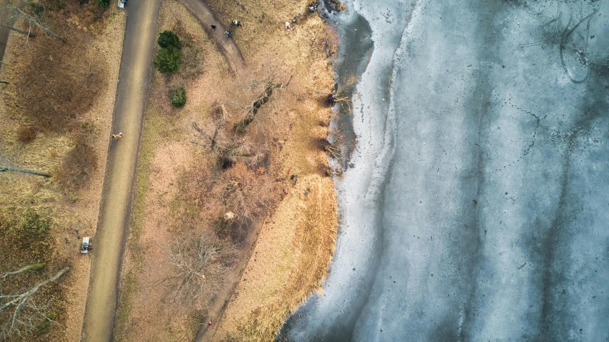 an aerial view of a road next to a body of water, by Adam Marczyński, pexels contest winner, land art, freezing, on a beach, thumbnail, unblur