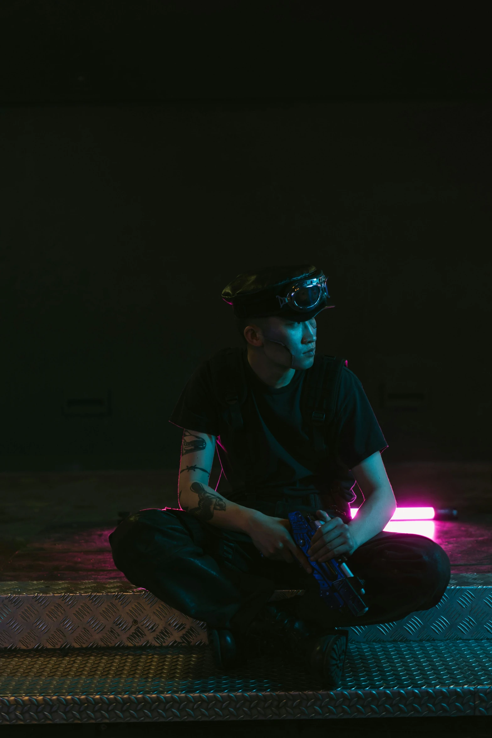 a man sitting on the ground in the dark, a hologram, unsplash, realism, he wears dark visors, yung lean, video game, armed