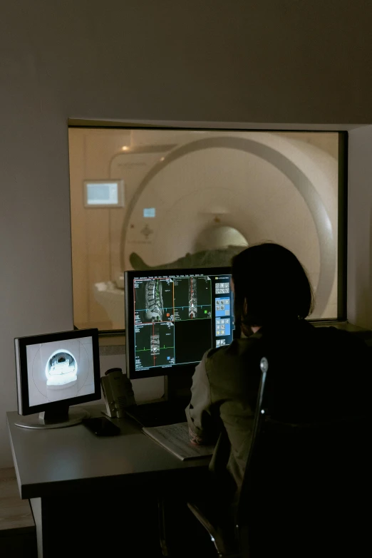 a person sitting at a desk in front of a computer, holography, mri, inside the tunnel, brown, null