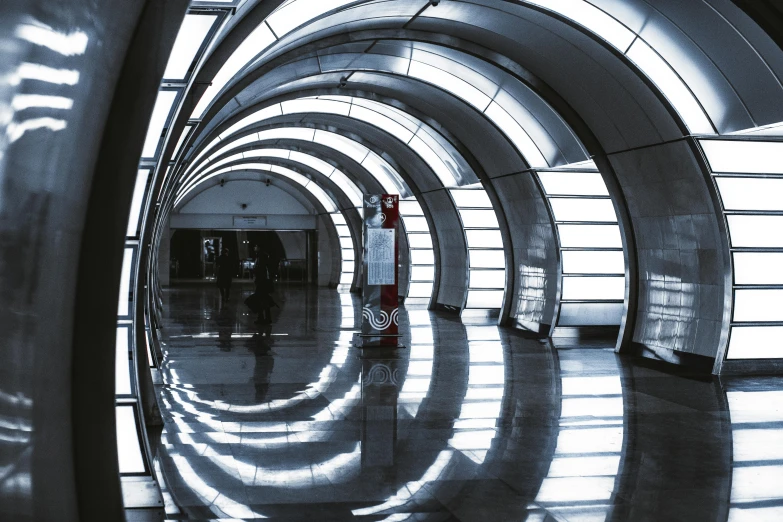 a black and white photo of people walking through a tunnel, inspired by Zaha Hadid, unsplash contest winner, hypermodernism, in moscow centre, open shiny floor, archway, metalic reflections