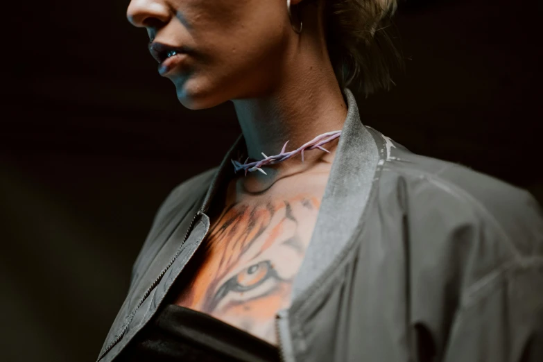 a woman with a tattoo on her chest, by Emma Andijewska, trending on pexels, hyperrealism, steel choker, purple and pink leather garments, barbed wire, woman in streetwear